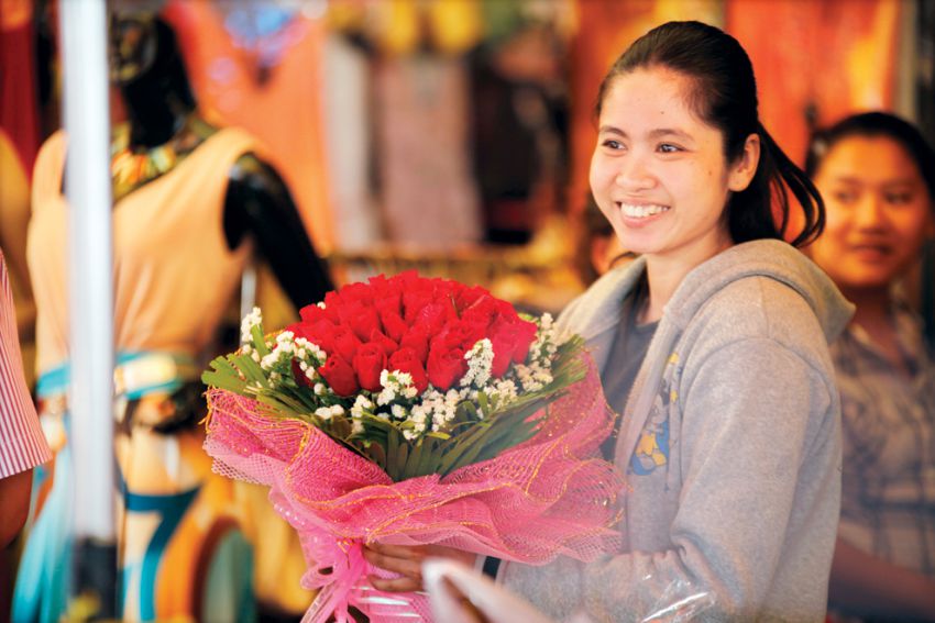 A woman held a branch of flower on the Valentine’s Day in 2013. HENG CHIVOAN